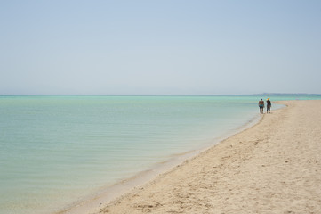 Fototapeta na wymiar Couple walking on a tropical beach