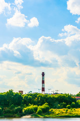 Fototapeta na wymiar Industrial landscape with clouds and greenery.