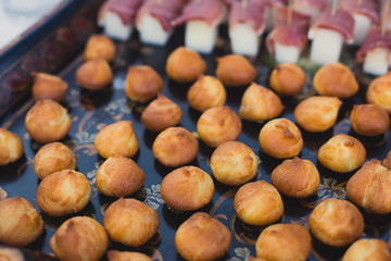 Beautifully decorated catering banquet table with different food snacks and appetizers with sandwich, caviar, fresh fruits on corporate birthday party event or wedding celebration 