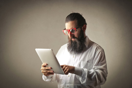 Long-bearded man using a tablet