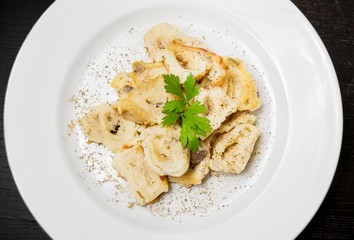top of view of dish of italian swivels pasta with porcini mushrooms and sauce bechamel with pepper