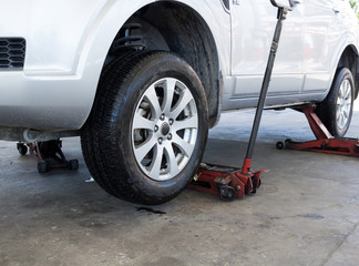 Fototapeta premium Tire replacement service fitting by hand jack