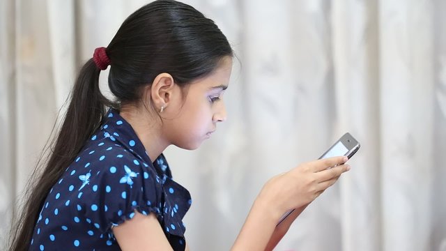 indian girl playing games on a tab and showing thumbs up after getting a winning point
