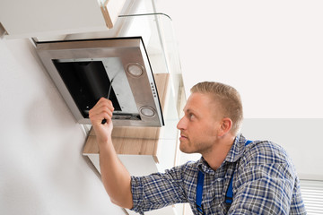 Worker Fixing Kitchen Hood