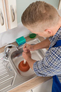 Worker Pressing Plunger In Sink