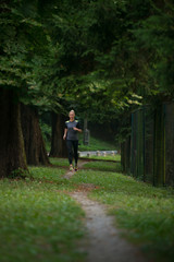 Woman Runner Running Through The Spring Park Road