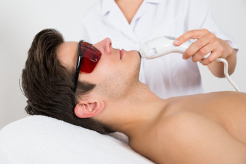 Naklejka premium Man Receiving Laser Hair Removal Treatment