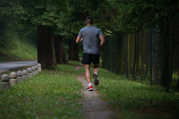 Male Runner Jogging During Outdoor Workout In Park