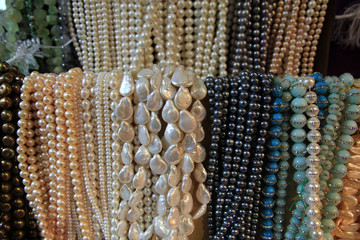 Many colorful necklaces of pearls as a background