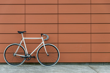 Fototapeta na wymiar White fixie bike in orange wall