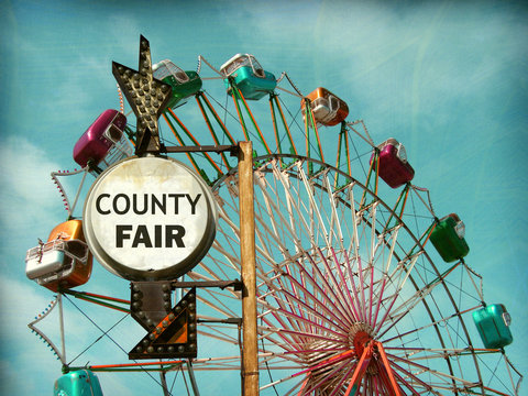 aged and worn vintage photo of county fair sign with ferris wheel