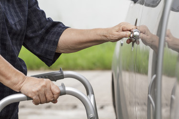 senior woman using a walker at car park