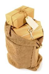 Brown paper wrapped package parcel inside a mail bag sack with blank label or gift tag isolated on white background photo