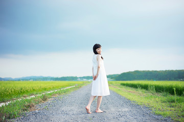 Fototapeta na wymiar 田舎道を歩く女性