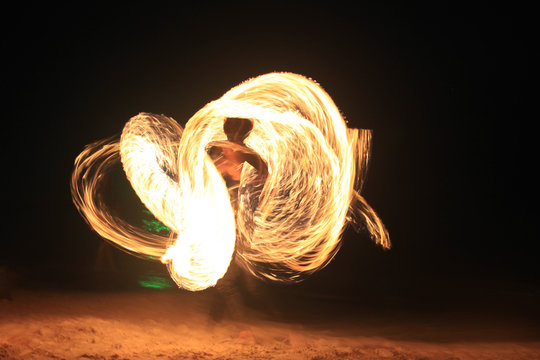 Fire-dancing in slow speed shutter photography on the beach