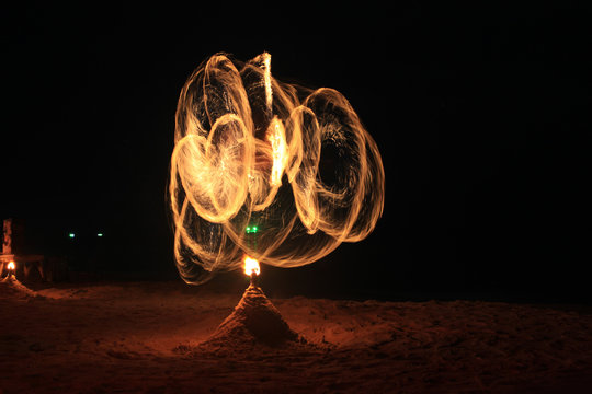 Fire-dancing in slow speed shutter photography on the beach