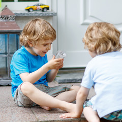 Obraz na płótnie Canvas Two happy sibling boys having fun together outdoors
