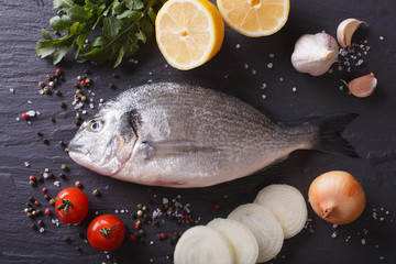 Raw fish dorado with the ingredients on the table. horizontal top view 
