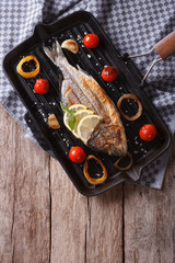 Dorado fish cooking on the grill pan close-up. vertical top view
