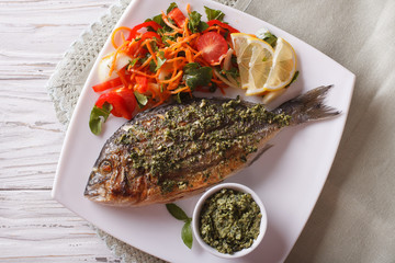 Grilled dorado fish with pesto and salad closeup. horizonta top view
