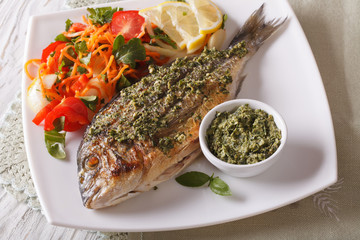 Grilled dorado fish with pesto and vegetable salad. horizontal
