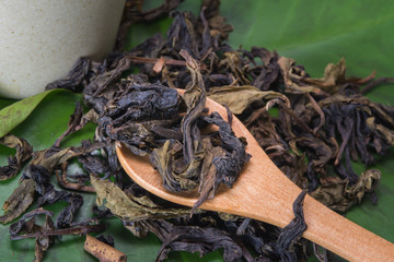 Dry tea leaves and wooden spoon