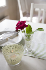 Tisch mit Kerze und Blumenvase