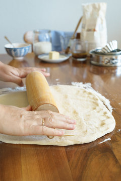 Rolling the yeast dough with rolling pin. Selective focus