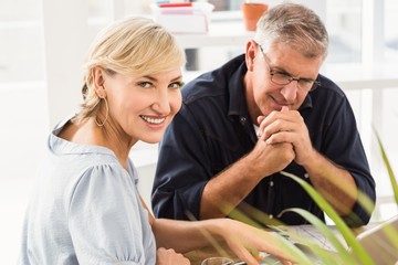 Fototapeta premium Smiling business team working on laptop