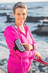 Fototapeta premium Smiling sporty woman enjoying music via headphones