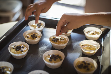 Hands of children decorating muffins with chocolate chips © anna_rostova