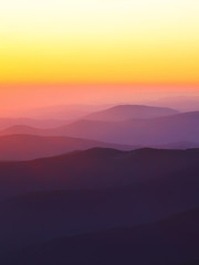 mountain peaks at sunset haze