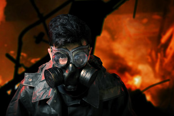 Сyberpunk stalker soldier in chemical protection armor and googles with flames background
