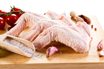 Raw chicken wings on cutting board on white background 