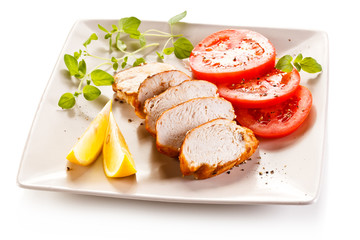 Roast chicken fillet and vegetables on white background 