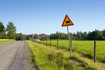 A warning sign on side of the road. This warning sign is for cattle. 