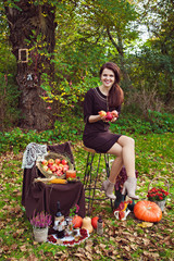 Young woman with apples in the hands in autumn park