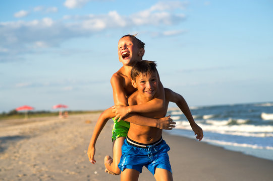 Happy Kids Playing On The Beach On Summer Holidays.