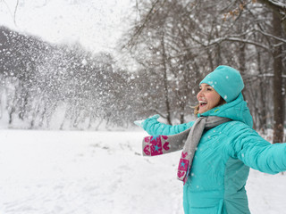 Fototapeta na wymiar Happy woman in blue jacket at the winter park.