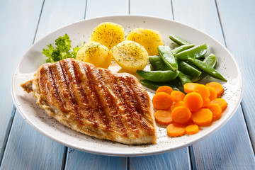 Roast chicken fillet and vegetables on white background 
