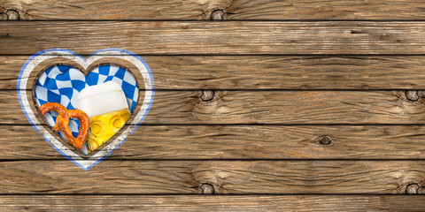 wooden oktoberfest background with heart shaped cut out beer pretzel and bavarian flag