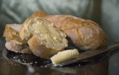 Bread with butter on knife on a plate