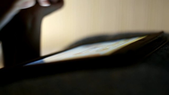 Close uo of kid hand touching screen of touch pad while playing video games
