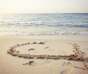 Heart written on sand.