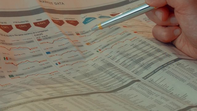 Investor analyzing stock quotes in a financial newspaper. Data about the main European stock markets can be seen.
