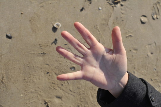 hand counting five on the beach