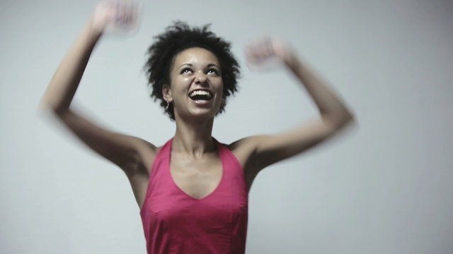 Happy african american woman showing success and winning at gray background