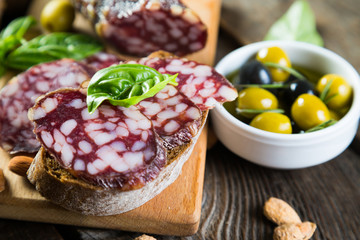 Sandwiches with salami, basil and olives