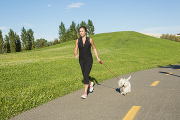 Beautiful young woman jogging with her dog
