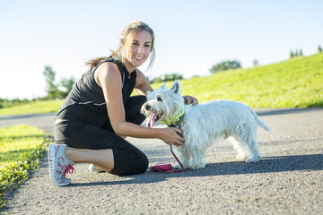 Beautiful young woman jogging with her dog